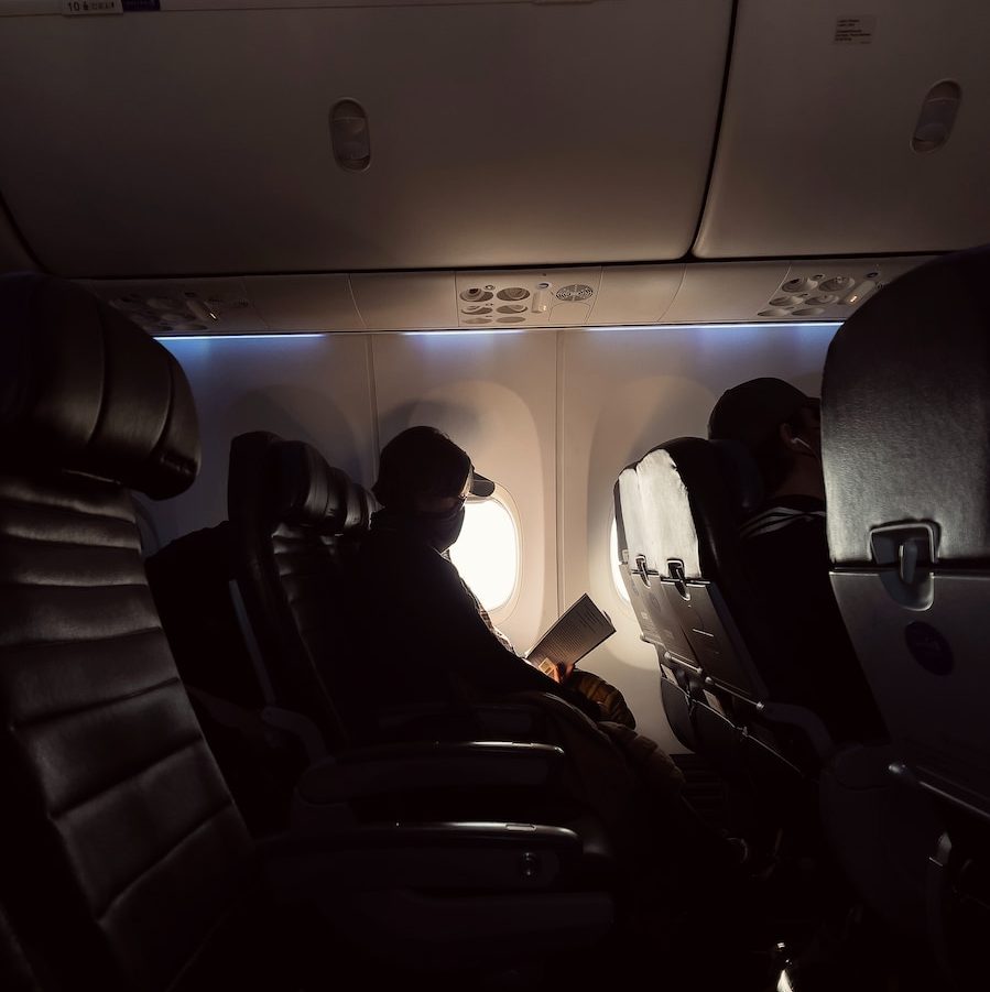 man in black jacket sitting on airplane seat