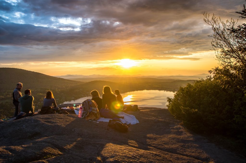 group of people sirring under sunset